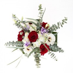 From the heart of Waterloo, this bouquet captures the rare blend of confident artistry and gentle comfort that marks the best of local floral design. The composition opens with a ring of large, snow-white gerbera daisies whose deep, chocolate-brown centers radiate a classic warmth, perfectly balanced by a cluster of rich red roses that sing with intimacy and enduring affection. Sprigs of delicate lavender and dusky purple lisianthus, some still curled in bud, are scattered throughout, introducing a poetic note of anticipation reminiscent of evening walks beneath the London Eye's gentle glow. Intertwined with clouds of soft, ivory filler flowers, the bouquet achieves harmonious volume without ever seeming crowded. Shimmering, silvery discs of eucalyptus add a contemporary edge and release a gentle, invigorating aroma that hints at the nearby Southwark gardens and parkland. Broad, lustrous dark green leaves fold elegantly at the base, enclosing the arrangement within a living frame. All these elements rest within a pristine glass vase, the water line gentle and clear, highlighting the verdancy of the freshly cut stems within. This luxurious yet unpretentious bouquet is a fitting choice whether it celebrates a loved one's special day, offers sympathy, or simply marks a moment of gratitude-always prepared with care by experienced Waterloo florists for same-day delivery throughout the neighbourhood.
