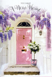 This image captures a tender moment outside a new home in Waterloo, where architecture and floristry combine to create a feeling of heartfelt welcome. A soft pink door stands at the centre, its carefully painted surface glowing gently against whitewashed walls that reflect a mellow, London afternoon light. Overhead, generous garlands of wisteria cascade in shades of lavender, lilac, and gentle violet, each dangling cluster made up of tiny, pea-like blossoms that spill down like a floral waterfall. Their presence gives the whole doorway a romantic, storybook charm, reminiscent of quiet residential streets tucked behind Waterloo Road or close to Baylis Road. Resting on the doorstep is a chic grey metal bucket, holding a lush bouquet of white and cream roses. The roses are full and open, with layered, velvety petals that invite the eye to linger, surrounded by sprigs of soft green foliage that add movement and depth. A blush pink ribbon is tied neatly around the bucket, its satin bow and trailing ends echoing the colour of the door and subtly uniting every element of the scene. The light is gentle and slightly golden, casting soft shadows on the step and along the contours of each bloom, as if the flowers have just been delivered as a housewarming surprise. The mood is calm yet full of anticipation, the perfect visual to accompany a new home card or to represent a same-day flower delivery welcoming someone to their first place in SE1, filled with promise, warmth, and the quiet reassurance of fresh flowers waiting at the threshold.